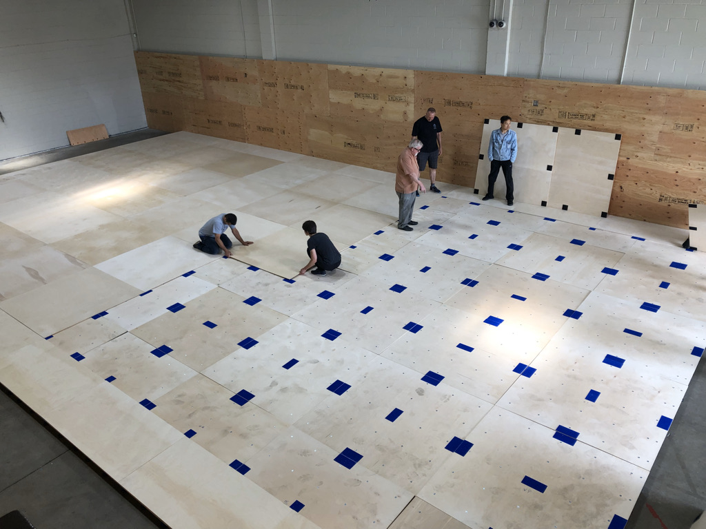 Installing the birch plywood layers of the sprung floor.