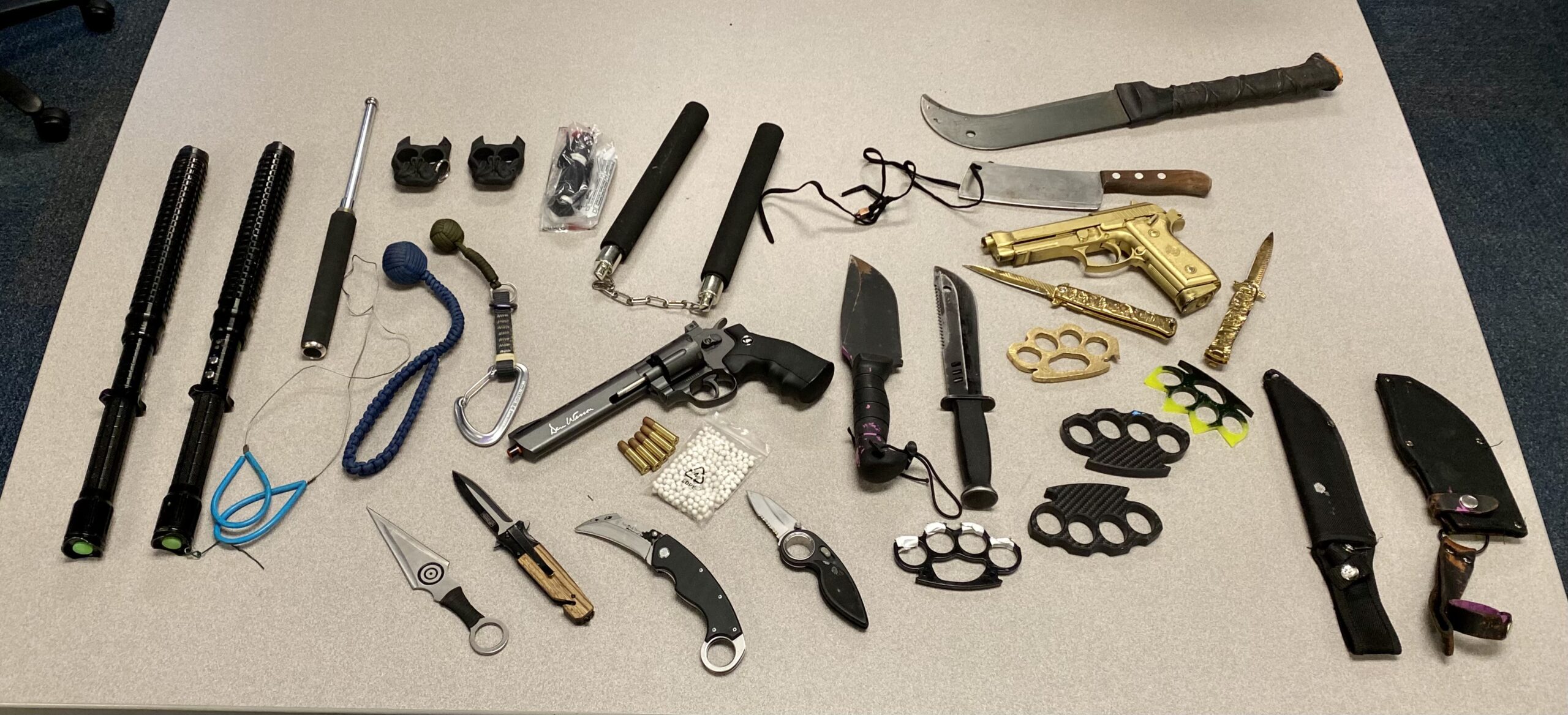 Assorted weapon and training reference items arranged on a table.